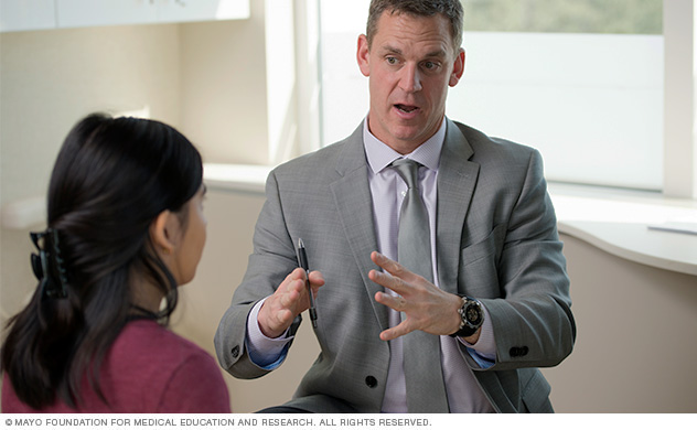 A urologic surgeon discusses treatment options with a patient.