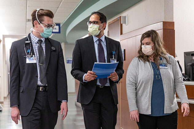 A Pancreas Clinic care team discusses care walking down a hallway.