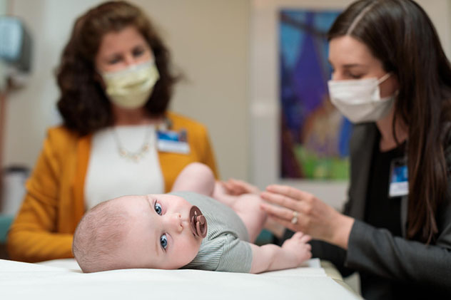 Two Pediatric Rehabilitation physicians interact with a very young child.