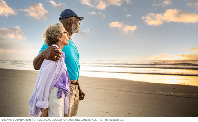 A couple on a Florida beach watches a sunrise.