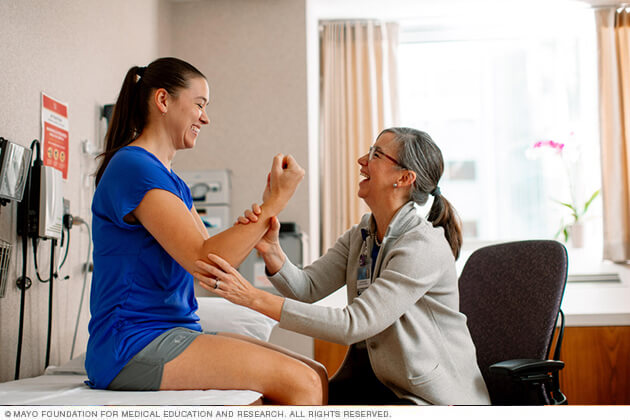 A therapist laughs with an adolescent patient during a session.