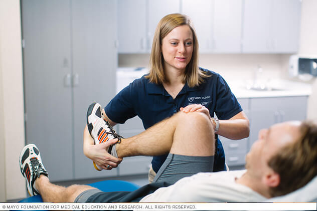 A Mayo Clinic physical therapy staff person works on knee mobility with a therapy patient.