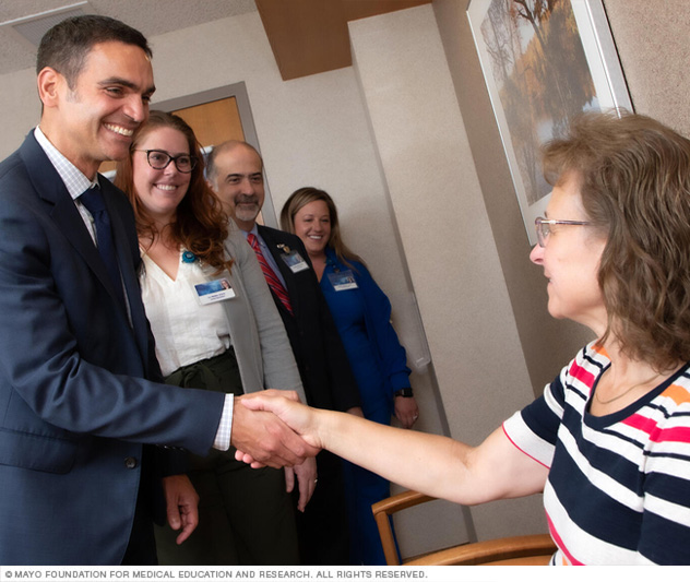 A dental care team greets a patient.