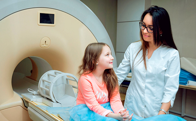 Healthcare provider with young girl and MRI scanner.