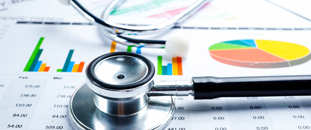 Stethoscope lying atop bar graphs, pie chart and columnar statistics