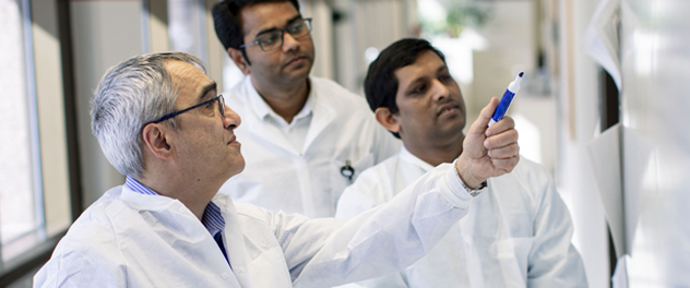 Researchers collaborating at a whiteboard