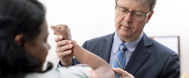 Dr. O'Driscoll examining a patient's elbow.