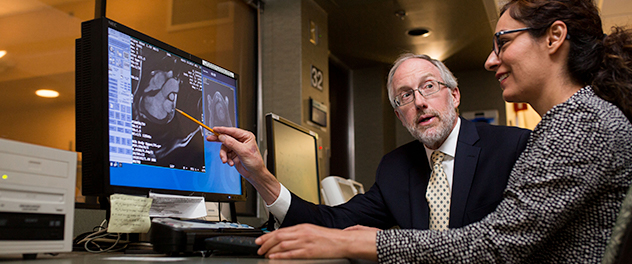 Stephen J. Riederer, Ph.D., analyzing MRI image with a trainee in the Magnetic Resonance Lab at Mayo Clinic