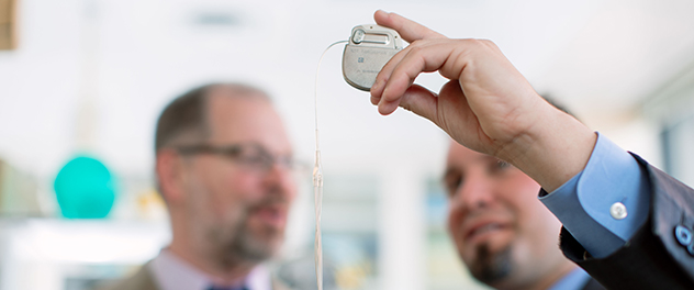 Dr. Worrell and his colleague examine a medical device.