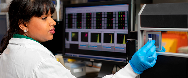 Photograph of a researcher using lab equipment in the Lerman lab at Mayo Clinic