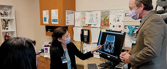 Clinician-investigators in exam room with patient