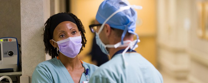 Two masked nurses in clinical setting