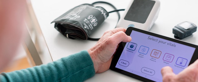 Close-up of hands entering vital signs on electronic tablet