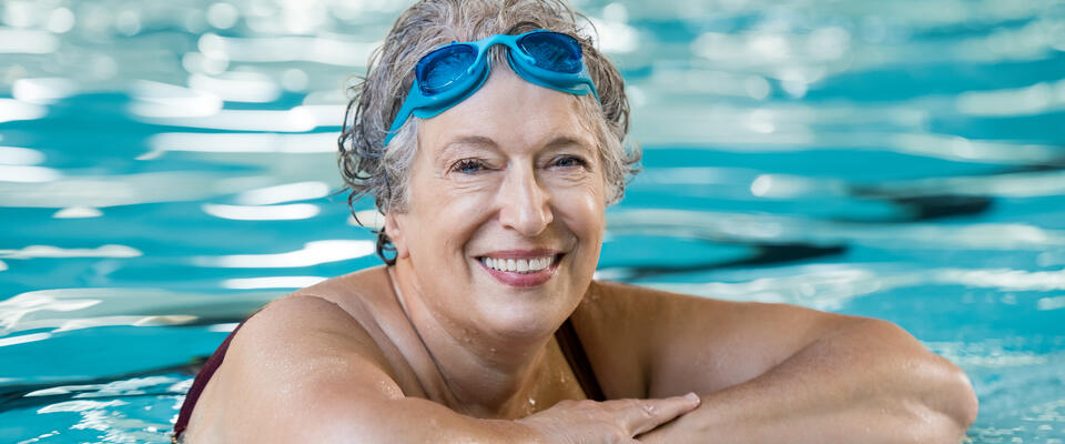 Image showing an older woman at the side of a pool with goggles on her forehead