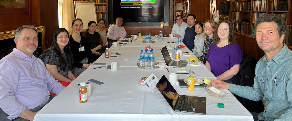 Lab team seated at long table in library