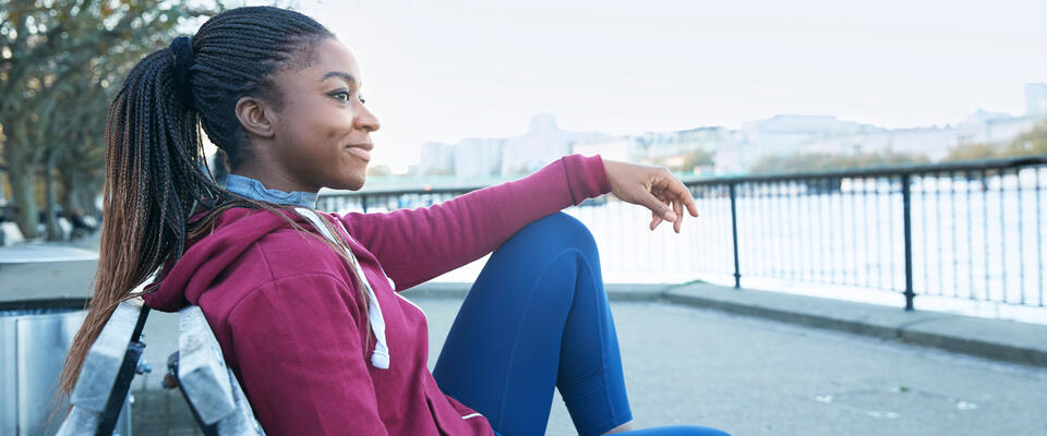 Photograph of a woman sitting outside on a park bench