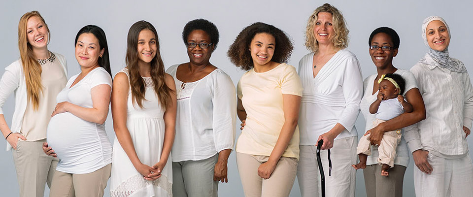 An ethnically diverse group of eight women in different stages of life.