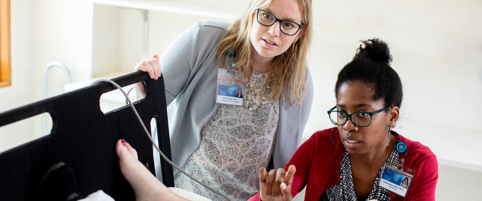 Researchers collecting and monitoring data from a patient