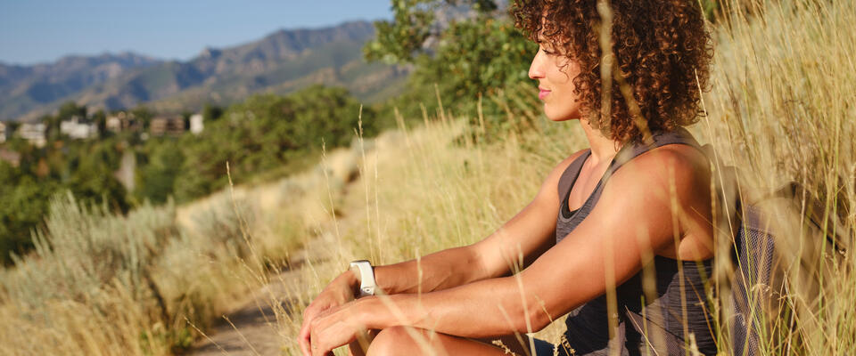 Woman sitting in profile in tall grass