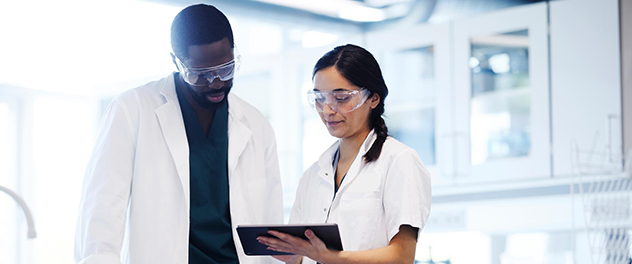 Man and woman in a lab look at a tablet computer